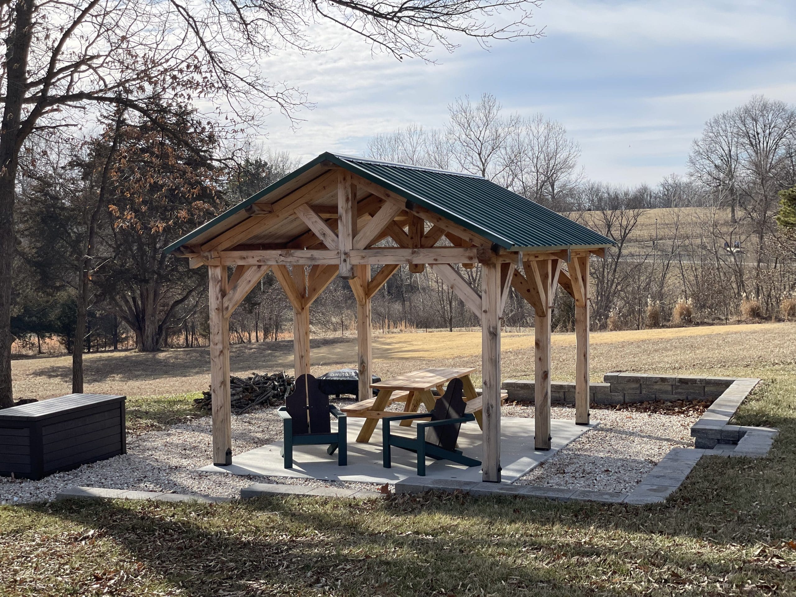 A timber framed pavilion with a seating area underneath. 